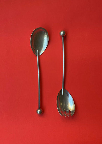 vintage serving spoons. red background.